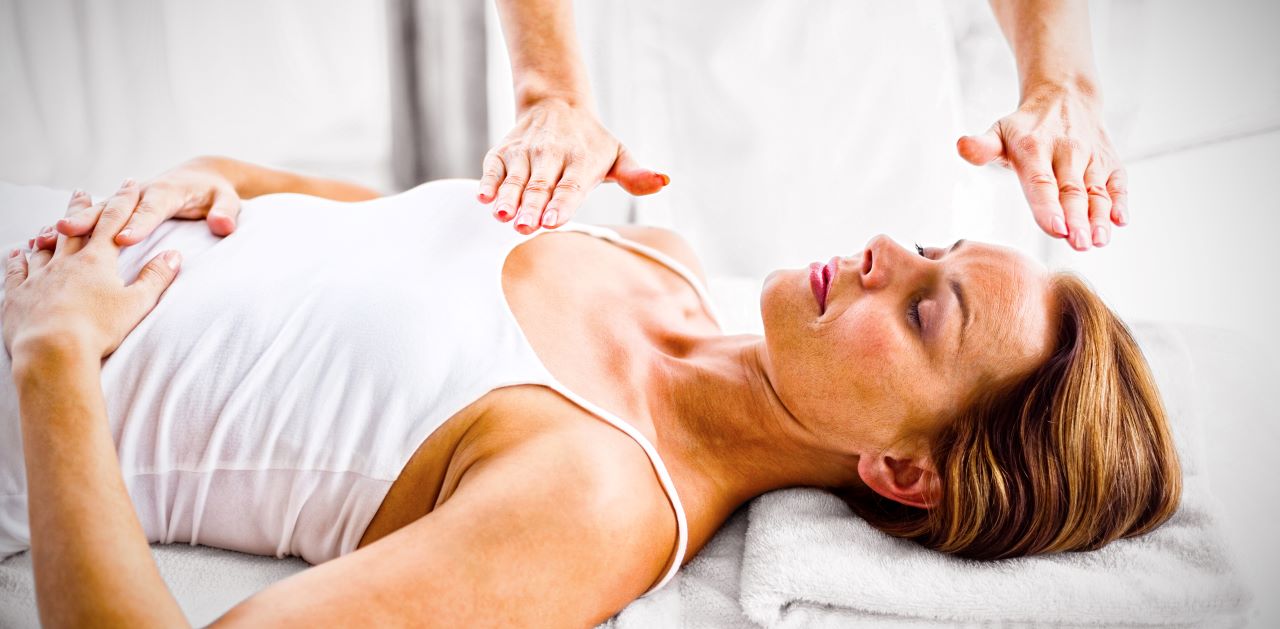 what is reiki healing; a woman performing reiki massage on another woman