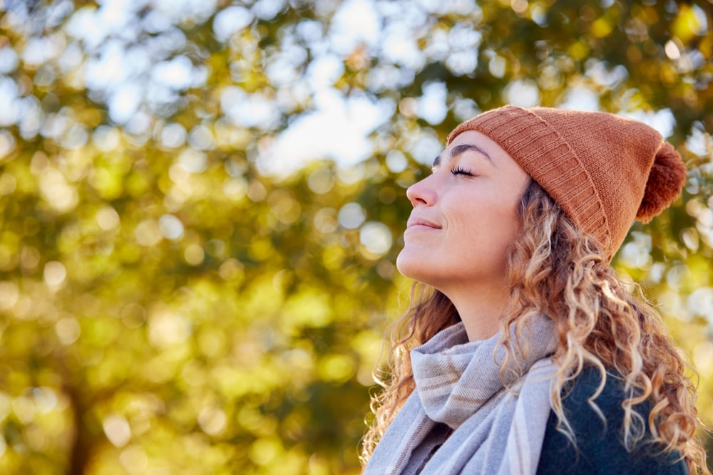 Women taking in the fresh air, wearing a beanie amongst trees and nature